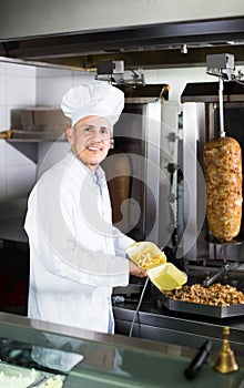 Man cook making kebab dish on kitchen in fast food restaurant