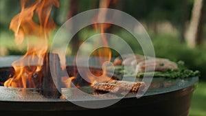 Man cooking bbq meat on grill outdoors. Man putting meat sticks with forceps