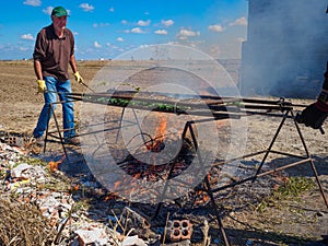 A man preparing a Calsotada, a barbecue with these grilled tender onions with a sauce photo