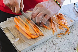 Man cooking, cut carrot julienne style