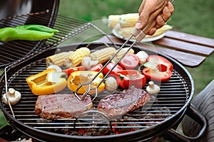 Man cooking food on barbecue grill outdoors