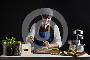 Man cooking green burger with beef, salad and vegetables.