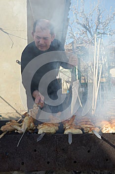 Man cooking grilled kebab cooking on metal skewer. Roasted meat cooked at barbecue. BBQ fresh chicken meat. Traditional eastern di