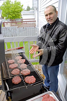 Man cooking hamburgers on a BBQ