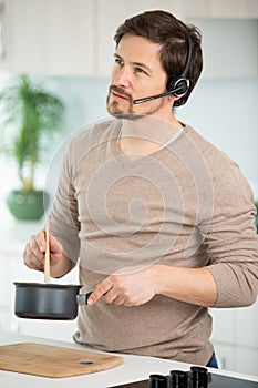 man cooking with headset standing at kitchen