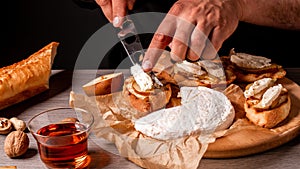 Man cooking Italian bruschetta with baked pear, honey, walnut and brie camembert cheese photo