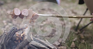 Man cooking meal near camping tent. Warming hotdog detail. Couple people in love autumn outdoor trip in nature. Fall