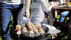 Man cooking meat on barbecue grill at summer party