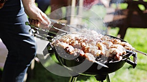 Man cooking meat on barbecue grill at summer party