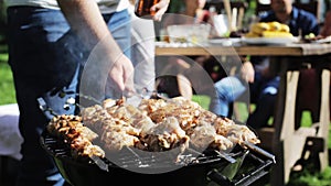 Man cooking meat on barbecue grill at summer party