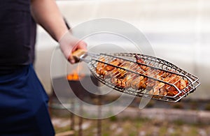 Man cooking meat on barbecue. Summertime fun
