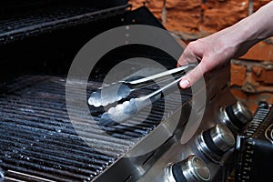 Man cooking meat steaks on professional grill outdoors