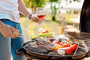 Man cooking meat and vegetables on barbecue grill outdoors