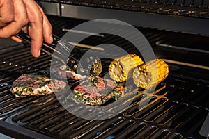 Man cooking meat and vegetables on BBQ