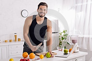 Man cooking near laptop and blender