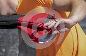 Man cooking outside reaches for heavy duty hot mitts with hand with black ring - closeup - selective focus