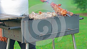 Man is Cooking Pork Barbecue Outdoors