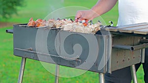 Man is cooking pork barbecue outdoors