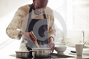 Man, cooking and pot with steam in the home for lunch or dinner, busy and hungry for food with preparation. Catering