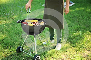 Man cooking tasty vegetables and meat on barbecue grill outdoors
