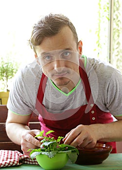 Man cooking vegetable salad (tomatoes, lettuce, cucumbers)