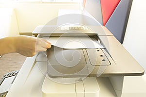 Man copying paper from Photocopier with access control for scanning key card sunlight from window