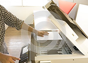 Man copying paper from Photocopier sunlight from window photo