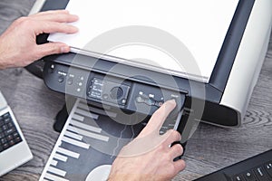 Man copying and scanning documents in office