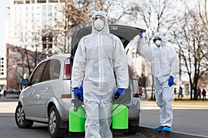 Man in coronavirus hazmat suit carrying disinfection gas