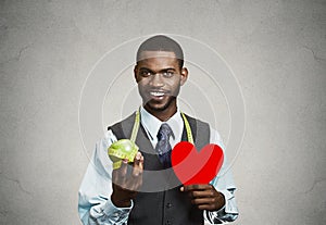 Man, corporate executive holding green apple, red heart