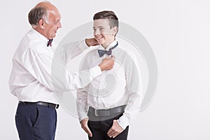 Man correcting the dicky bow of his grandson