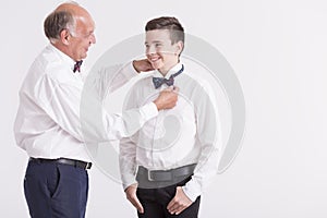 Man correcting the dicky bow of his grandson photo