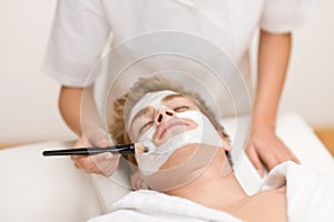 Man cosmetics - facial mask in spa salon