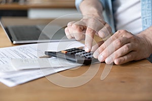 Man costs personal incomes and expenses using calculator close up photo