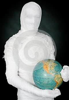 Man in costume mummy and terrestrial globe