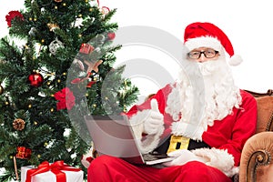 Man in costume of santa claus with laptop