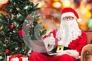 Man in costume of santa claus with laptop
