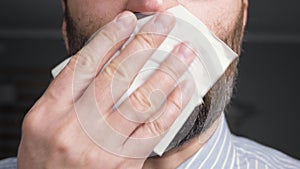 Man coughs and covers her mouth with napkin. Colds, flu, laryngitis, tuberculosis, asthma, bronchitis, allergies