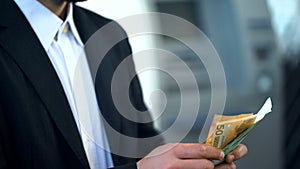 Man counting euros in bank branch, interest on deposit, profitable investment