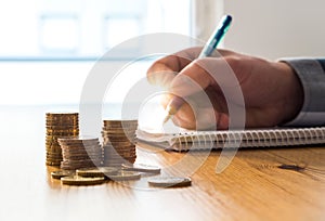 Man counting expenses, budget and savings and writing notes.