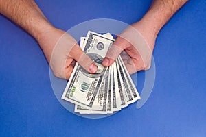 Man counting money on a blue background