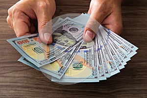 Man counting paper dollar banknotes. 100 usd dollar bills in hands close up