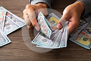 Man counting paper dollar banknotes. 100 usd dollar bills in hands close up