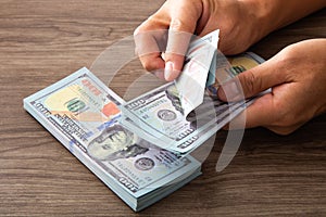 Man counting paper dollar banknotes. 100 usd dollar bills in hands close up