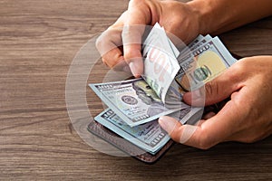 Man counting paper dollar banknotes. 100 usd dollar bills in hands close up