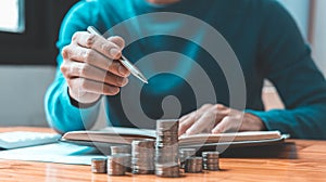 Man counts the coins piled up on the table in preparation to save money