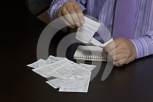 The man counts the cost of cash Cheques. A family budget. photo