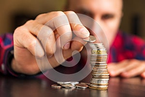 Man counts his coins on a table photo