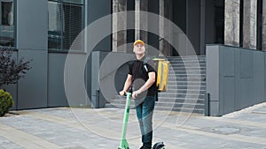 Man courier on scooter delivering food in town streets with a hot food delivery from takeaways and restaurants to home