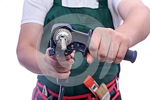 Man in coverall holding drill machine isolated on white